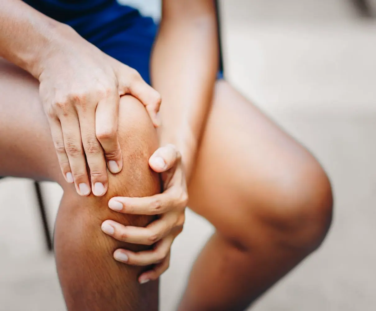 man holding his knee and putting pressure